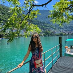 a woman is standing on a dock by the water