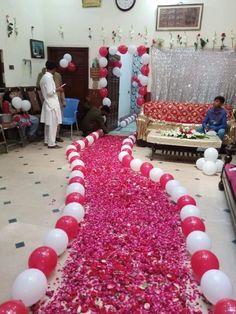 a long line of red and white balloons in the middle of a room filled with people