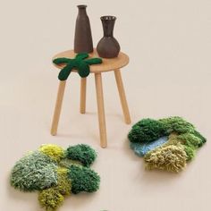 two vases and some grass on a table