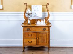 an antique wooden dresser with two vases on top