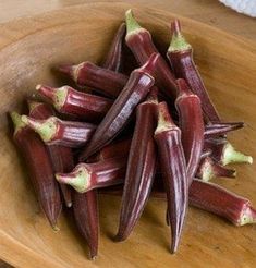 there is a wooden bowl filled with purple flowers