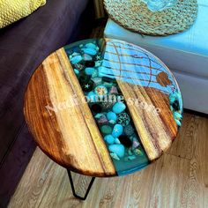 a table that has some rocks in it on top of a wooden floor next to a couch