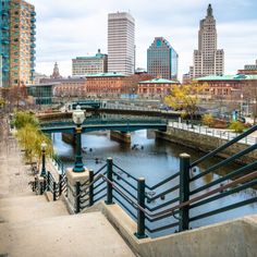 a bridge over a river in front of tall buildings