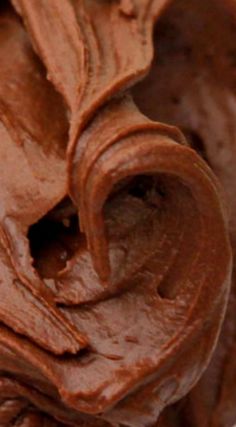 a close up view of chocolate frosting in a bowl