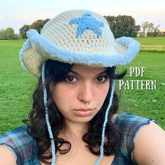 a young woman wearing a crocheted hat on top of her head in the grass