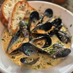 a white bowl filled with clams and bread