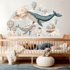 a baby's room with a whale and hot air balloons mural on the wall