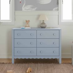 a blue dresser sitting next to a window in a room with white walls and carpet