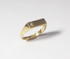 A 14k solid gold signet engagement ring with a diamond. This lovely minimal and clean designed signet ring is made of solid 14k gold and has a small diamond on one side (1.5 ct). The shiny diamond is set in a star designed inlay, which gives this ring yet more character and sparkle. This ring can be a great modern engagement ring or a high-class gift for any other happy occasion such as birthdays, births, anniversaries and more. This rin is great for everyday use - it is light and comfortable to White Gold 14k Signet Ring With Single Cut Diamonds, Gold 14k Signet Ring With Single Cut Diamonds, Modern Formal Signet Ring With Single Diamond, Minimalist Diamond Signet Ring With Polished Finish, Gold Engraved Ring With Single Diamond For Promise, Timeless Gold Engraved Ring With Single Diamond, Gold Minimalist Ring With Single Cut Diamonds, Signet Ring With Single Cut Diamonds As Gift, Gold 14k Brilliant Cut Signet Ring