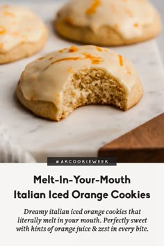 orange cookies with white icing are on a table