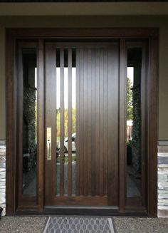 a modern wooden door with glass panels and sidelights on the front of a house