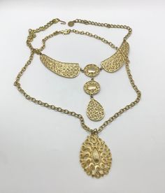 Lot of 2 super cool vintage mid-century gold tone necklaces, sold together only. First one is a fun collar necklace with an ornate circular geometric design. Original necklace was super short, so an extender has been added for adjustability. Hook closure, you can hook to where you like it. Approximately 18.25 inches maximum length. Second necklace has a vintage teardrop shaped medallion. Original clasp was degraded and replaced with a large lobster claw. Adjustable also. 24 inches length, pendan Ornate Metal Choker Necklace, Bohemian Gold Metal Choker, Ornate Gold-tone Metal Jewelry, Bohemian Gold Medallion Necklace In Brass, Gold Bib Necklace Costume Jewelry, Gold Bib Choker Costume Jewelry, Antique Gold Choker Jewelry, Adjustable Gold Bib Choker Necklace, Gold Costume Jewelry Bib Necklace