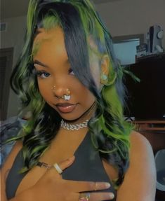 a woman with green and black hair has piercings on her nose to look like she is looking at the camera