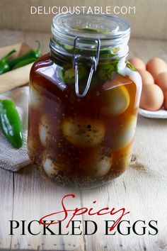 a jar filled with food sitting on top of a wooden table next to eggs and green peppers