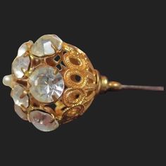 This sparkling hatpin is ready to be worn and admired! A lovely example dating from the Victorian / Edwardian era. From top to bottom it measures 4 inches long. The pierced gold gilt frame measures 6/8 of an inch wide. Gilt is holding up beautifully as are the glistening paste stones. In the right lighting they come alive! Largest ones have an average width of 6.25mm, smaller ones 4.50mm. The top is finished off with a faux pearl. All rhinestones are in place and held securely. Top pearl shows a Heirloom Gold Evening Brooches, Heirloom Gold Brooches For Evening, Victorian Gold Brooch With Screw Back, Victorian Gold Brooch For Wedding, Victorian Gold Brooches For Evening, Victorian Gold Wedding Brooch, Ornate Gold Brooches For Vintage Events, Antique Gold Brooches For Wedding, Classic Gold Brooches For Vintage Events