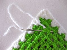 the crochet pattern is being worked on by someone using scissors to make it look like an ornament