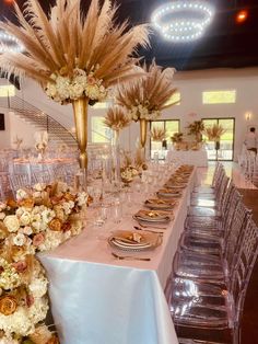 a table set up for a formal function with tall centerpieces and flowers on the tables