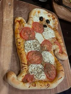 a pizza with toppings on it sitting on a cutting board