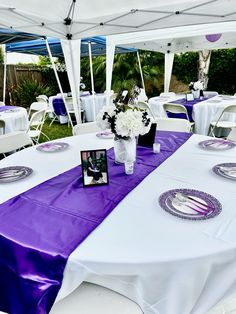 the table is set with purple and white linens