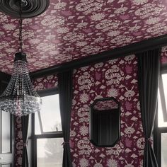 a chandelier hangs from the ceiling in front of a floral wallpapered room