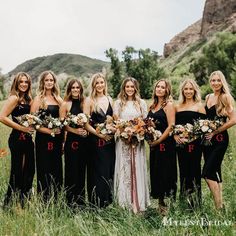 a group of women standing next to each other in a field with flowers on them