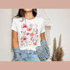 Introducing our Wildflowers T-Shirt, a blossoming beauty that captures the essence of nature's vibrant colours. This floral-inspired tee is designed for ladies who appreciate the delicate charm of wildflowers. It's the perfect gift for women, whether it's for your best friend or a dear friend who loves floral motifs. Our premium t-shirt is crafted with utmost care, ensuring both comfort and softness. Made from 100% cotton, it offers a luxurious feel against your skin. The heather colours feature a blend of 52% cotton and 48% polyester, combining durability and style in one. Fabrication: * Solid colours: Crafted with 100% cotton for a luxurious feel * Heather colours: Blending 52% cotton and 48% polyester for durability and comfort * Light fabric material that runs true to size, providing a T Shirt Flowers, Floral Tee, Flower Shirt, Gift For Friend, Floral Motifs, Vibrant Colours, Floral Shirt, Gift For Women, Dear Friend