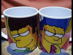 two coffee mugs with the faces of homer and bart on them