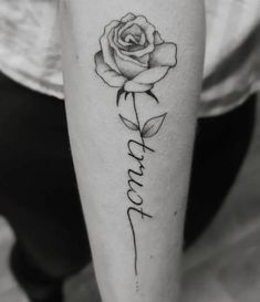 a black and white photo of a rose with the word love tattooed on it's leg