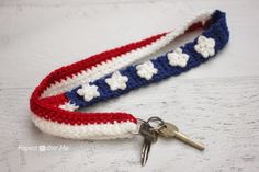 a red, white and blue crochet key fobl with flowers on it