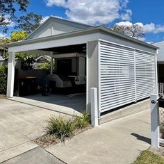 a house with a garage attached to the side and covered in shutters on both sides