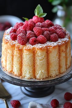 a cake topped with raspberries on top of a table