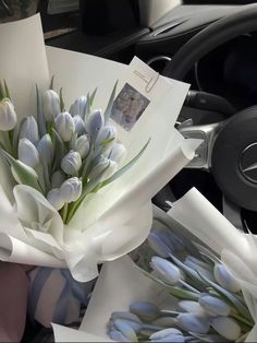 a bouquet of flowers sitting on top of a table next to a car steering wheel