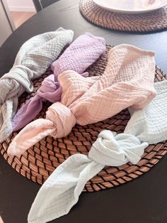 several scarves are sitting in a wicker basket on top of a black table