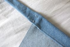 a piece of blue fabric with holes in the middle on a white sheet that has been stitched together