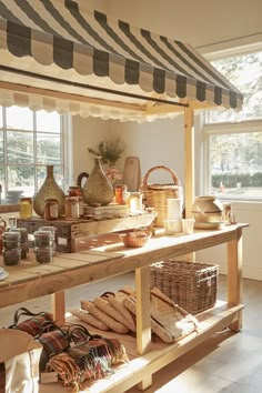 an assortment of breads and baskets on a table in front of a large window