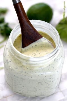 a wooden spoon sticking out of a jar filled with dressing