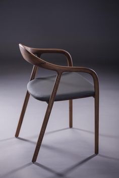 a wooden chair with grey upholstered seat and armrests, viewed from the front