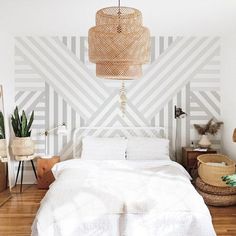 a white bed sitting in a bedroom on top of a hard wood floor next to a wall