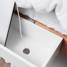 an open drawer on the side of a bed