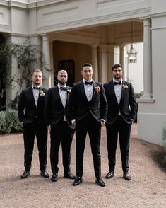 a group of men standing next to each other in tuxedos and bow ties