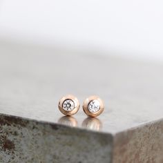 "These two 14k rose gold stud earrings are tiny and perfect for everyday wear. They feature sparkly 2mm moissanite gemstones set into solid gold (not hollow) lenti-shaped studs. These recycled, diamond alternative studs are ready to ship. These are the perfect every day earrings with just the right amount of flash. They would be great in a second piercing or as a barely-there, never-take-'em-off stud in your regular piercing. This listing is for a pair of earrings. These earrings measure 4mm acr Minimalist Rose Gold Diamond Earrings, Dainty Rose Gold Diamond Earrings For Everyday, Everyday Dainty Rose Gold Diamond Earrings, Minimalist Rose Gold Earrings With Single Diamond, Minimalist Rose Cut Diamond Earrings As Gift, Minimalist Earrings With Rose Cut Diamonds For Gift, Minimalist Rose Gold Hypoallergenic Diamond Earrings, Minimalist Rose Gold Diamond Earrings With Single Diamond, Rose Gold Single Diamond Earrings For Gift