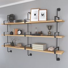 three shelves with books and pictures on them in a room next to a wall mounted clock