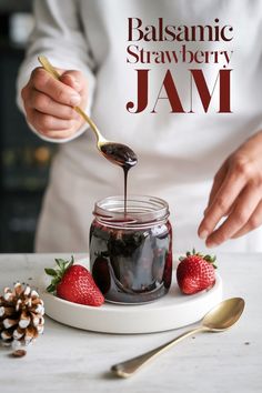 A visually appealing jar of balsamic strawberry jam being spooned out with a gold spoon. The jam is a rich, dark color with visible strawberry pieces, showcasing its thick and luscious texture. Two fresh strawberries with vibrant green leaves rest beside the jar on a white ceramic plate, adding a pop of color and freshness. A pinecone adds a rustic, wintery touch to the scene, suggesting this jam as a seasonal treat or holiday gift idea. Macerated Strawberries, Strawberry Jam Recipe, Strawberry Preserves, Strawberry Jelly, Cake Studio, Savory Dishes, Jam Recipe, How To Make Jam, Fruit Jam