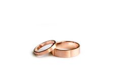 two gold wedding rings sitting on top of each other