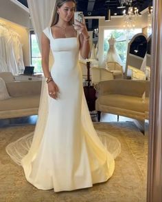 a woman is taking a selfie in her wedding dress while standing in front of a mirror