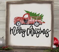 a red truck with a christmas tree on the back is sitting in front of a wooden frame