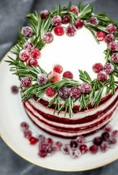 a christmas cake decorated with cranberries and greenery on a plate stock photo