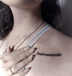 a woman with her hand on her chest has a tattoo that reads, there's someone behind her