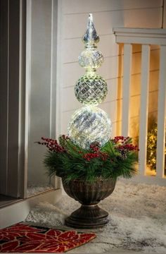 a vase with christmas decorations in it sitting on the ground