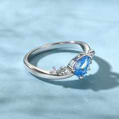 This sterling silver ring, adorned with the essence of the ocean, captures the essence of tranquility and majesty. At its heart lies an ocean blue pear-shaped stone, shimmering with a subtle wave pattern. This unique cut stone appears to be a frozen wave, capturing the essence of the sea's movement in a single moment. The ring's design is inspired by the undulating waves that lap against the shore, each curve and contour mimicking the graceful dance of the sea. The sterling silver band is sleek Elegant Teardrop Birthstone Promise Ring, Elegant Teardrop Topaz Gemstone Ring, Elegant Silver Teardrop Crystal Ring, Fine Jewelry Blue Pear-shaped Topaz Ring, Fine Blue Topaz Ring Pear-shaped, Elegant Teardrop Topaz Ring In Sterling Silver, Elegant Sterling Silver Pear-shaped Topaz Ring, Elegant Silver Pear-shaped Topaz Ring, Elegant Teardrop Crystal Promise Ring